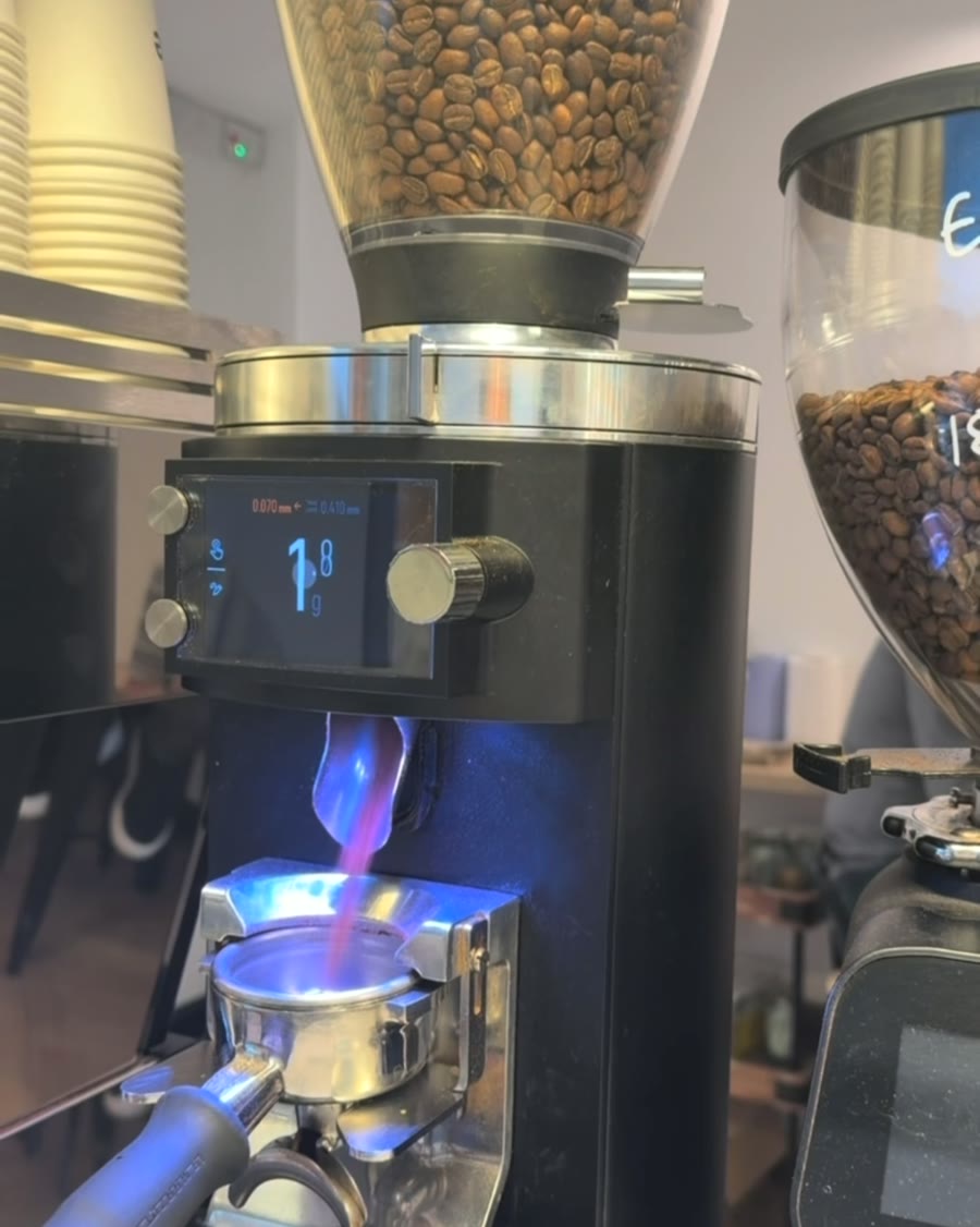 Espresso grinder dosing fresh coffee into a portafilter at Thrive